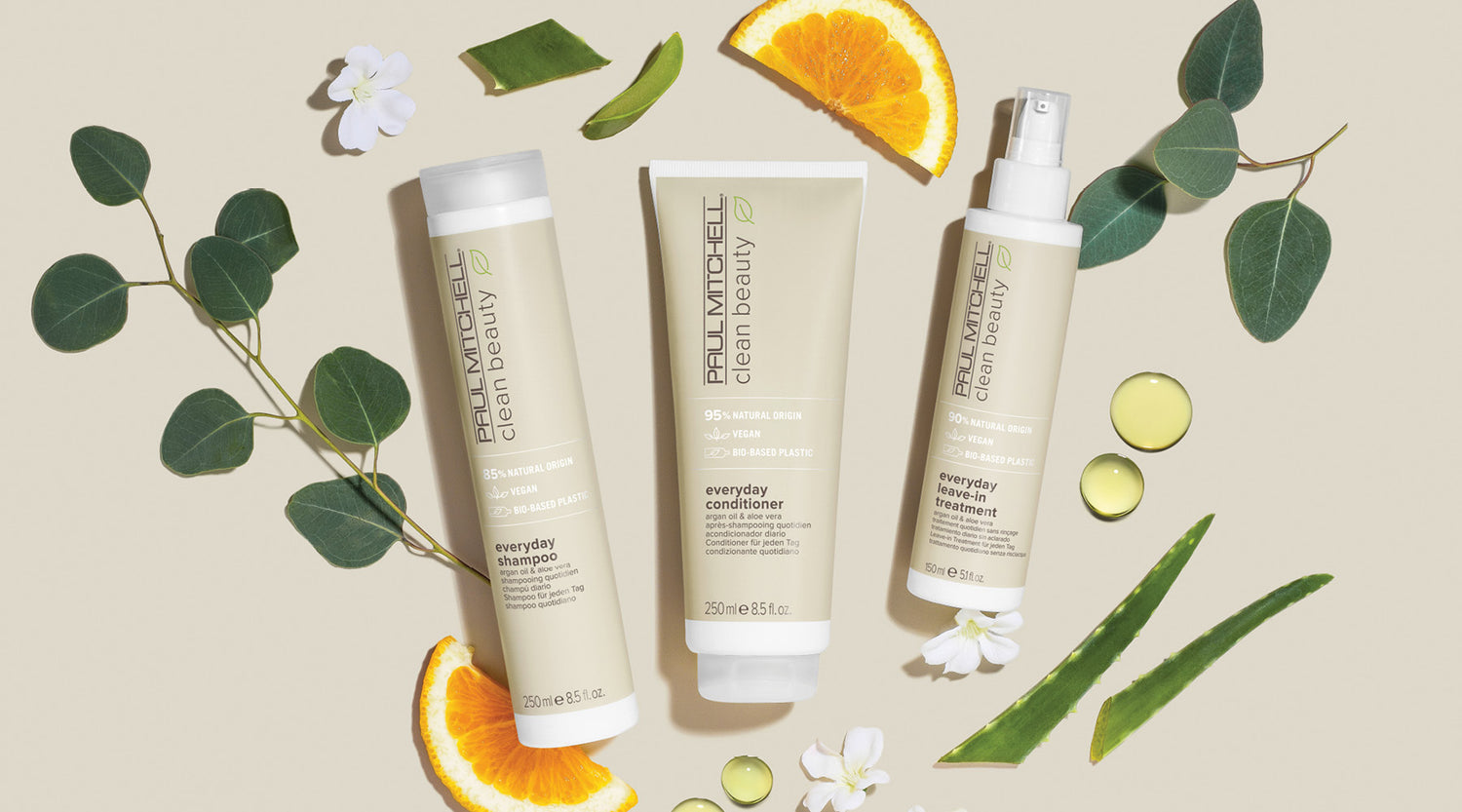 Produkte auf beigefarbenem Hintergrund mit Orangenscheiben und Aloe Vera – für die tägliche Haarpflege.