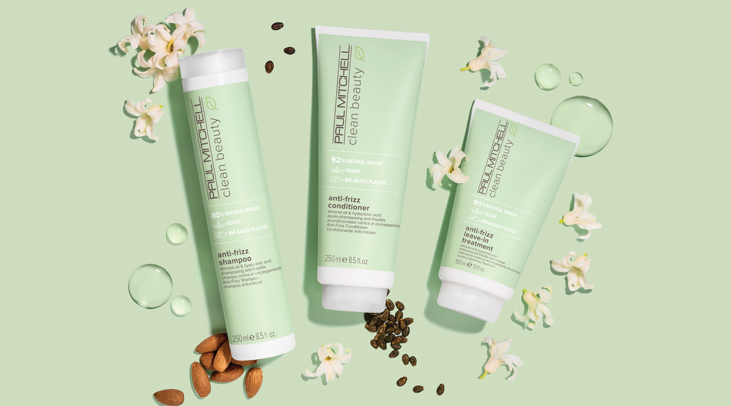 Produkte auf grünem Hintergrund mit mandeln, blüten und Öl  – für glattes, gepflegtes Haar.