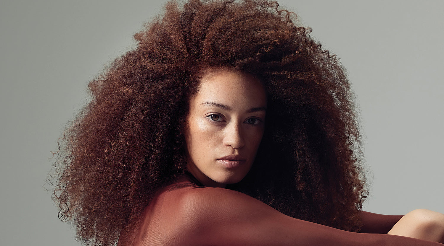 Frau mit leuchtend gefärbtem Haar – vermittelt Glanz und Farbschutz.