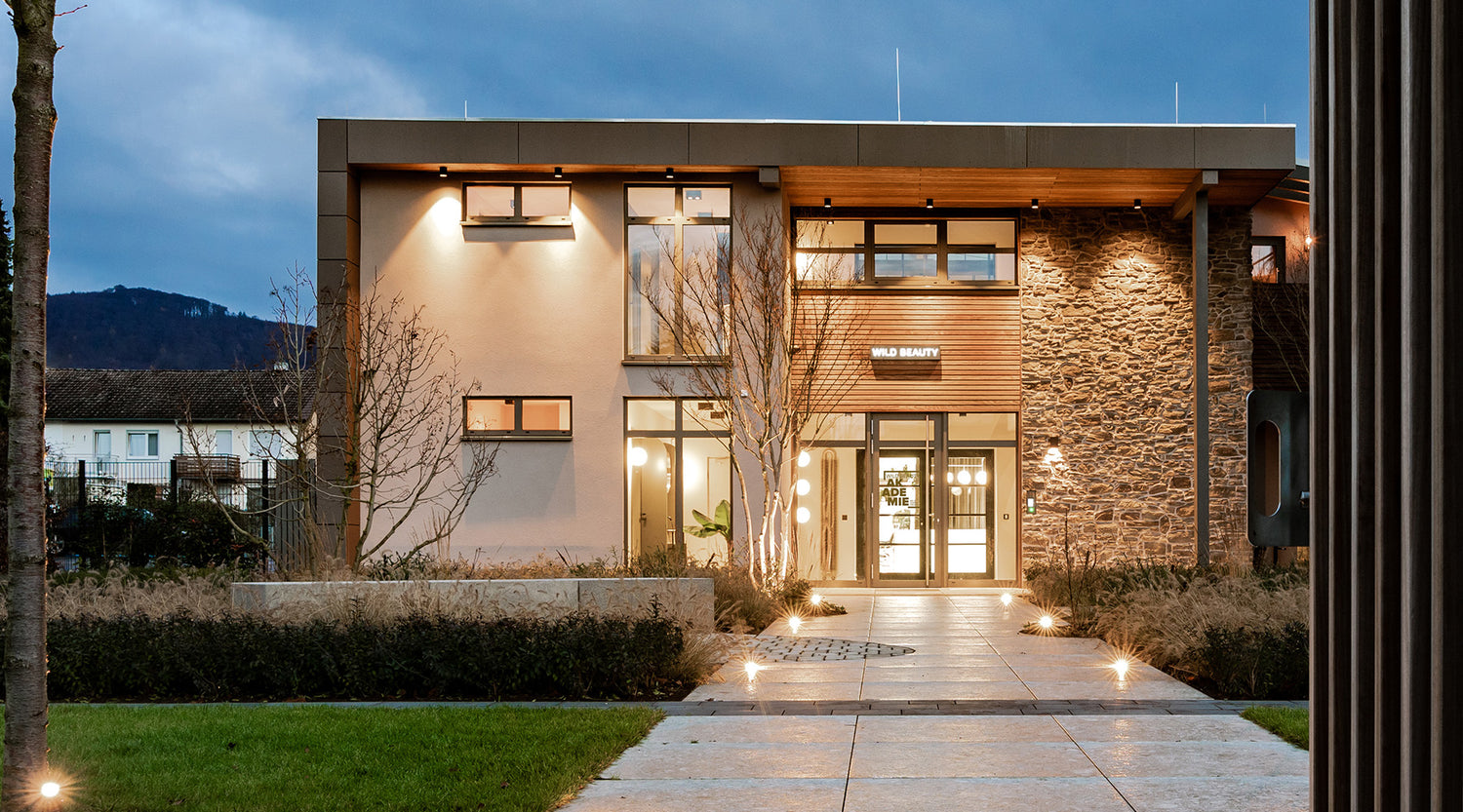 Wild Beauty Akademie Gebäude frontale Ansicht mit Lichtern an