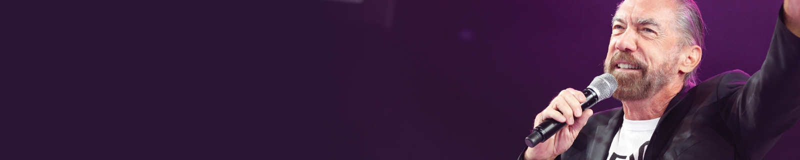 Banner John Paul Mitchell hällt eine Rede auf Bühne